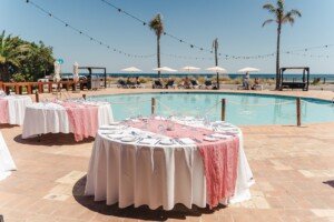 A chic wedding ceremony set directly on Meia Praia beach with the modern Duna Beach Bar and ocean as the backdrop. Beach wedding ceremony with chairs on the sand in front of the modern Duna Beach Bar at Tivoli Lagos Algarve Resort.